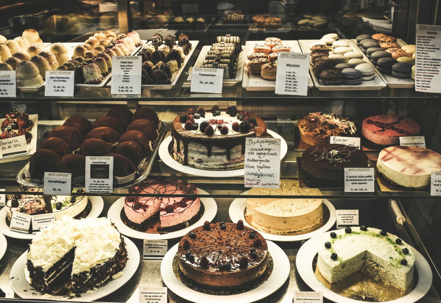 A patisserie counter full of cakes and macarons